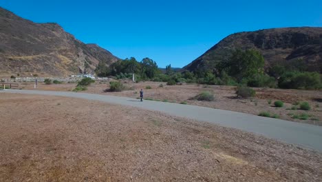 Aerial-footage-following-a-man-riding-an-electric-unicycle-down-a-road-in-California-4