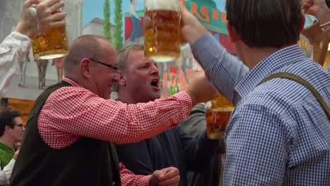 Alle-Stoßen-Mit-Bierkrügen-Auf-Dem-Oktoberfest-Deutschland-An