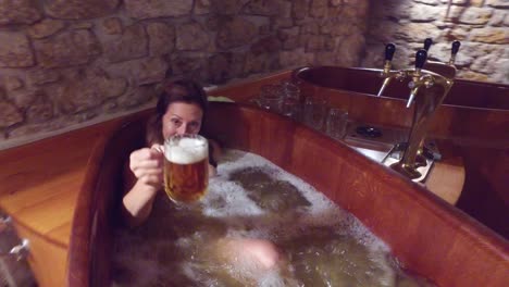 A-woman-in-a-beer-spa-toasts-from-a-tub-of-boiling-beer
