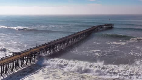 Aerial-over-huge-waves-rolling-in-over-a-California-pier-in-Ventura-California-during-a-big-winter-storm-suggests-global-warming-and-sea-level-rise-or-tsunami