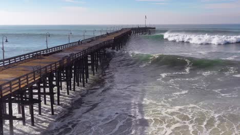 Aerial-over-huge-waves-rolling-in-over-a-California-pier-in-Ventura-California-during-a-big-winter-storm-suggests-global-warming-and-sea-level-rise-or-tsunami-1