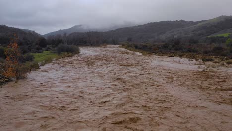 Antenne-Von-Hochwasser,-Das-Sich-Schnell-Den-Ventura-Fluss-In-Kalifornien-Hinunter-Bewegt,-Mit-Abfluss-Bei-Winterwetterüberschwemmungen-1