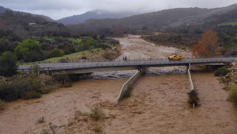 Antenne-Von-Hochwasser,-Das-Sich-Schnell-Den-Ventura-Fluss-In-Der-Nähe-Von-Ojai,-Kalifornien,-Mit-Abfluss-Während-Der-Überschwemmung-Des-Winterwetters-Hinunter-Bewegt