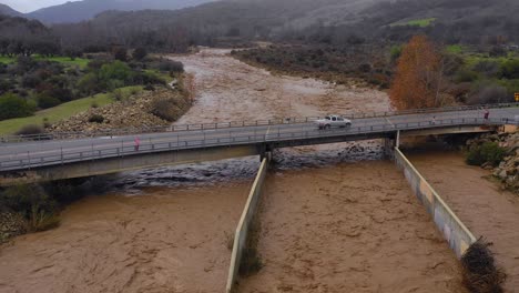 Vista-Aérea-of-flood-waters-moving-fast-down-the-Ventura-Río-near-Ojai-California-with-runoff-during-winter-weather-flooding-1