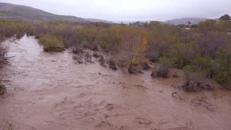 Pan-A-Través-De-Las-Aguas-De-La-Inundación-Moviéndose-Rápidamente-Por-El-Río-Ventura-Cerca-De-Ojai-California-Con-La-Escorrentía-De-La-Tormenta-Durante-Las-Inundaciones-De-Invierno