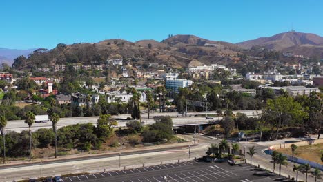 A-drone-aerial-of-Southern-California-beach-town-of-Ventura-California-with-freeway-foreground-and-mountains-background