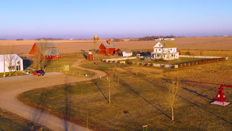 A-drone-aerial-establishing-shot-over-a-classic-farmhouse-farm-and-barns-in-rural-midwest-America-York-Nebraska