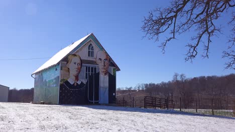 A-rural-barn-has-a-rendition-of-Grant-Wood's-American-Gothic-painting-on-the-side-1