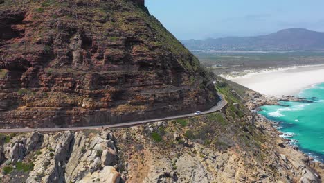 Eine-Luftaufnahme-Eines-Autos,-Das-Auf-Einer-Gefährlichen-Schmalen-Bergstraße-Entlang-Der-Ocean-Chapmans-Peak-Road-In-Der-Nähe-Von-Kapstadt-Südafrika-Fährt-2