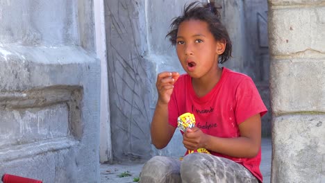 Ein-Junges-Mädchen-Isst-Snacks-In-Der-Bunten-Bo-kaap-Malaiischen-Gegend-Von-Kapstadt-Südafrika-Mit-Kolonialen-Gebäuden-Und-Verkehr