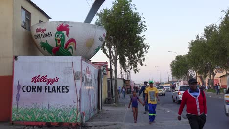 Eine-Schüssel-Mit-Kellog&#39;s-Cornflakes-Steht-Neben-Einer-Belebten-Straße-In-Der-Innenstadt-In-Der-Südafrikanischen-Gemeinde-Gugulethu