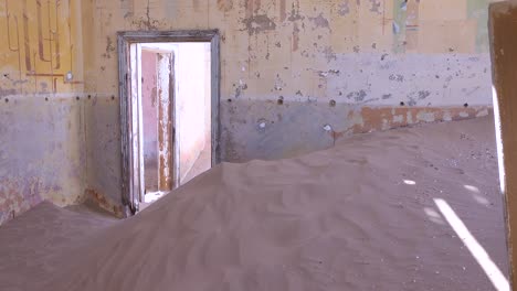 Sand-Weht-Durch-Ein-Verlassenes-Gebäude-In-Der-Edelsteinbergbau-Geisterstadt-Kolmanskop,-Namibia-1