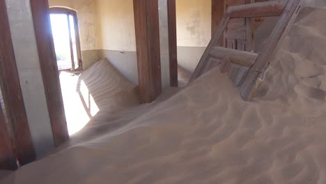 Sand-Weht-Durch-Ein-Verlassenes-Gebäude-In-Der-Edelsteinbergbau-Geisterstadt-Kolmanskop,-Namibia-4