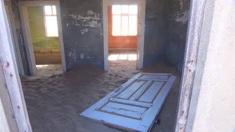 Sand-Füllt-Ein-Verlassenes-Gebäude-In-Der-Edelsteinbergbau-Geisterstadt-Kolmanskop,-Namibia-1