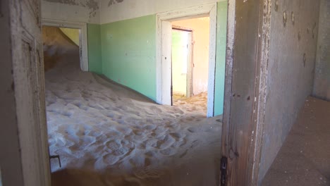 Sand-Füllt-Ein-Verlassenes-Gebäude-In-Der-Edelsteinbergbau-Geisterstadt-Kolmanskop,-Namibia-3