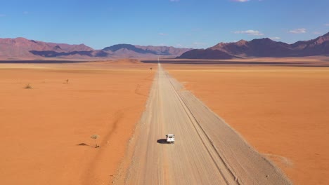 High-aerial-over-a-Toyota-safari-vehicle-heading-across-the-flat-barren-Namib-Desert-in-Namibia-6
