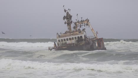 Un-Barco-De-Arrastre-De-Pesca-En-Tierra-Naufragio-Espeluznante-Se-Asienta-En-Las-Olas-Del-Atlántico-A-Lo-Largo-De-La-Costa-Esquelética-De-Namibia-1