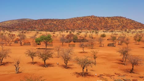 Low-aerial-over-a-Himba-African-tribal-settlement-and-family-compound-in-northern-Namibia-Africa