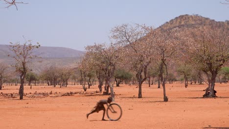 Pobre-Niño-Africano-Juega-Con-Una-Rueda-De-Bicicleta-Como-Un-Juguete-En-Una-Aldea-Himba-En-La-Frontera-De-Namibia-Y-Angola