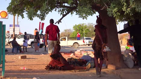 Native-Himba-tribal-men-and-women-stand-around-in-the-streets-of-Opuwo-Namibia-with-traffic-passing