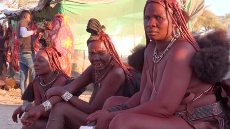 Tres-Mujeres-Tribales-Himba-Se-Sientan-Junto-A-La-Carretera-En-La-Ciudad-Comercial-De-Opuwo-Namibia-Con-Increíbles-Peinados-Trenzados-Empapados-De-Barro-Y-Rastas
