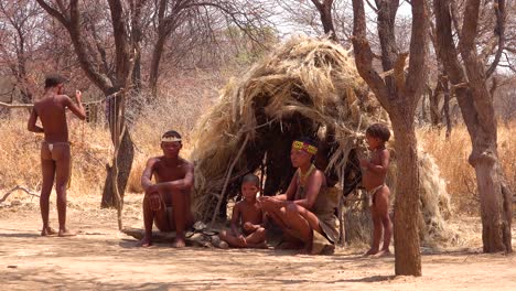 Afrikanische-San-Stammes-Buschmänner-Familie-In-Ihren-Hütten-In-Einem-Kleinen-Primitiven-Dorf-In-Namibia-Afrika