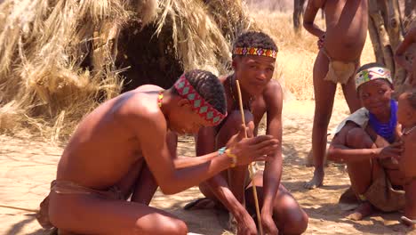 Afrikanische-San-Stammes-Buschmänner-Machen-Feuer-Auf-Traditionelle-Weise-In-Einem-Kleinen-Primitiven-Dorf-In-Namibia