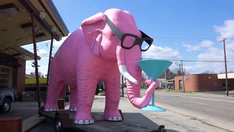 A-giant-pink-elephant-sits-beside-the-road-with-a-martini-in-its-trunk-in-a-small-town-in-rural-Fortville-Indiana-1