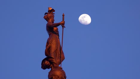 Statue-atop-Soldiers-and-Sailors-Monument-with-moon-rising-in-downtown-Indianapolis-Indiana