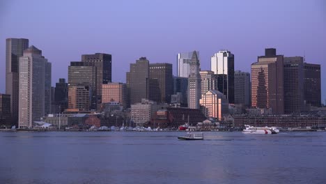 Skyline-of-downtown-Boston-Massachusetts-with-water-taxi-at-night-or-dusk