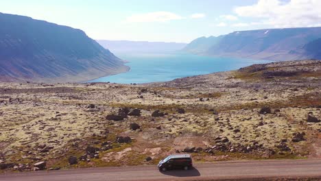 Antenne-über-Einem-Schwarzen-Wohnmobil,-Das-Auf-Einer-Unbefestigten-Straße-In-Island-In-Den-Nordwestlichen-Fjorden-Unterwegs-Ist-2