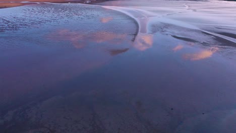 Luftaufnahme-Von-Wolkenreflexionen-In-Gezeitenbucht-Und-Sonnenuntergangsmustern-In-Der-Nähe-Von-Rau______isandur-Strand-Westfjorde-Island