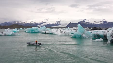 A-zodiac-boat-makes-its-way-through-icebergs-in-a-melting-glacier-lagoon-at-Jokulsarlon-Iceland