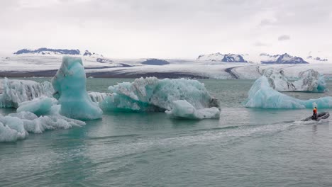 A-zodiac-boat-makes-its-way-through-icebergs-in-a-melting-glacier-lagoon-at-Jokulsarlon-Iceland-1