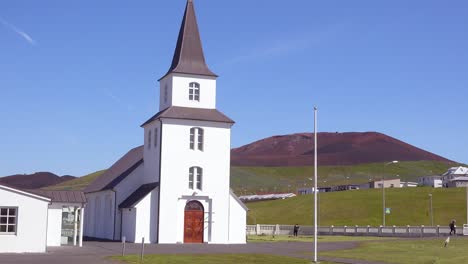 A-church-below-Eldfell-volcano-looming-over-Heimaey-in-the-Westman-Islands-Vestmannaeyjar-Iceland-