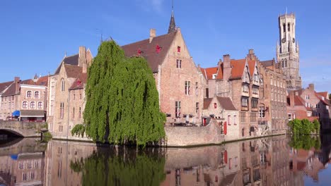 Pan-across-beautiful-canal-and-the-Belfort-Van-Brugge-Bruges-belfry-bell-tower-in-Belgium