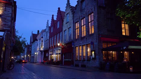 Calle-De-Tiendas,-Restaurantes-Y-Canal-Por-La-Noche-En-Brujas,-Bélgica