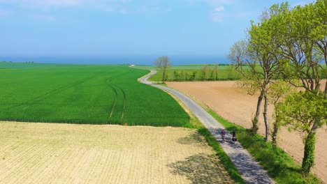 Schöne-Antenne-Eines-Französischen-Paares,-Das-Fahrrad-Durch-Die-Grüne-Landschaft-Der-Normandie-Frankreich-Fährt-1