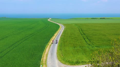 Beautiful-aerial-of-a-French-couple-riding-bicycles-through-the-green-countrside-of-Normandy-France-2
