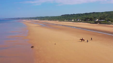 Aerial-over-dogs-running-and-horse-and-rider-on-Omaha-Beach-Normandy-France-site-of-World-War-two-D-Day-allied-invasion-1