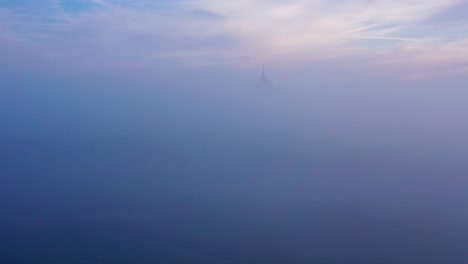 Moody-amazing-aerial-of-Mont-Saint-Michel-France-rising-out-of-the-mist-and-fog-in-early-morning-1