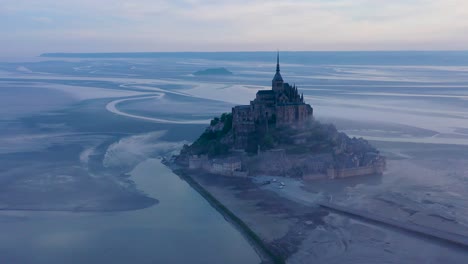 Foggy-aerial-of-Mont-Saint-Michel-France-in-the-mist-and-fog-in-early-morning