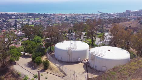 Aerial-over-water-tanks-high-on-a-hill-above-the-city-of-Ventura-California