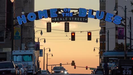 Hermosa-Toma-De-Establecimiento-De-Beale-Street-Sign-Memphis,-Tennessee-Con-Carritos-Pasando-Y-Hogar-Del-Blues-Al-Atardecer