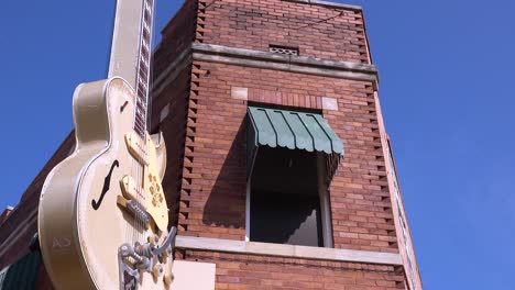 Una-Guitarra-Cuelga-Fuera-De-Un-Edificio-De-Ladrillos-Sun-Studios-Música-Studio-En-Memphis,-Tennessee