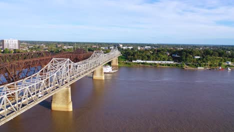 Gute-Antenne-über-Einem-Schaufelraddampfer-Des-Mississippi,-Der-Unter-Drei-Stahlbrücken-In-Der-Nähe-Von-Memphis-Tennessee-Hindurchfährt