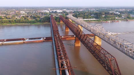Antenne-Des-Flusskahns-Unter-Drei-Stahlbrücken-über-Den-Mississippi-Mit-Memphis-Tennessee-Hintergrund-1