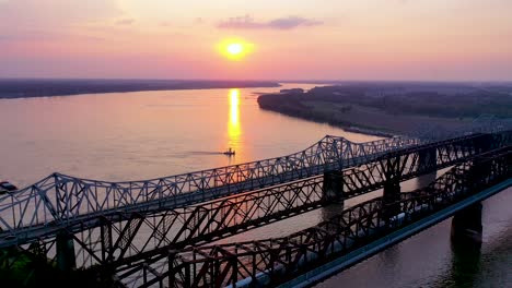Antenne-Des-Wahrzeichens-Drei-Stahlbrücken-über-Den-Mississippi-Bei-Sonnenuntergang-Mit-Memphis-Tennessee-Hintergrund-1