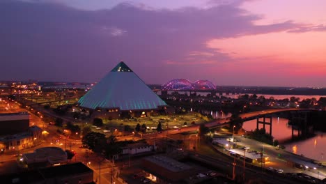 Schöne-Nachtluftaufnahme-Der-Memphis-Pyramide-Hernando-De-Soto-Brücke-Und-Des-Stadtbildes-In-Der-Abenddämmerung