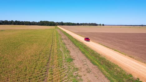 Luftaufnahme-Eines-Roten-Pickup-Trucks,-Der-Auf-Einer-Unbefestigten-Straße-In-Einem-Ländlichen-Farmgebiet-Von-Mississippi-Unterwegs-Ist-3